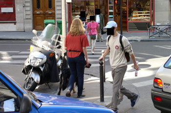 A motorbike parked on the pavement blocks the pedestrian crossing.